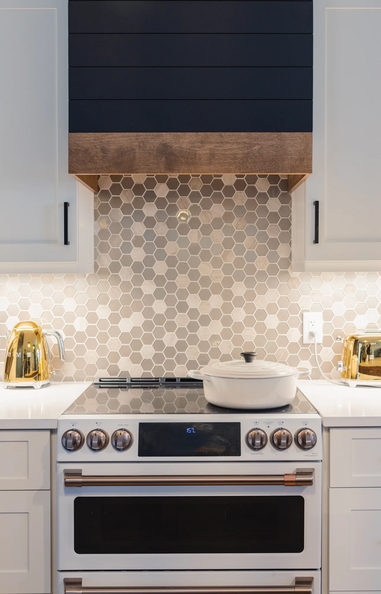 Renovated Halifax kitchen with a timber range hood and hexagonal tile backsplash, designed by MAD Design Interiors